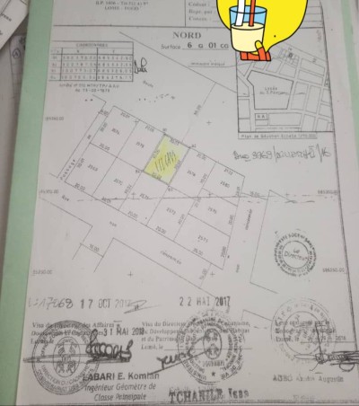 1 lot cloturé avec 3 tampons au bord du goudron